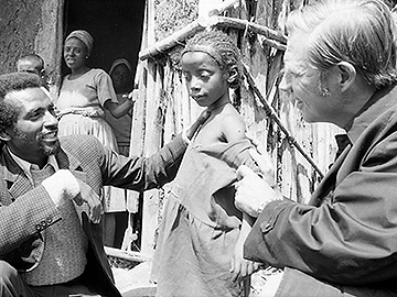Dr. Donald A. Henderson (right), who led the World Health Organization effort to eradicate smallpox, examines a child's vaccination scar in Ethiopia.